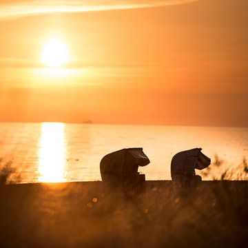 Strandkörbe im Sonnenaufgang am Meer an der Ostsee