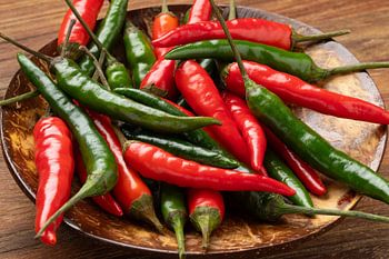 Bowl of fresh whole red and green rawit hot peppers