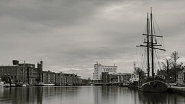 Warehouses on the Zaan under cloudy skies (black and white) by Bram Lubbers