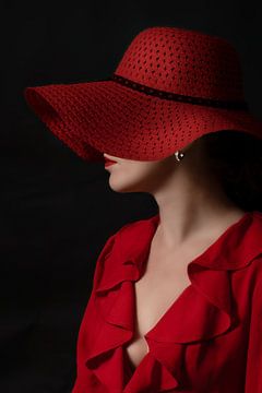 La dame au chapeau et au chemisier rouges.