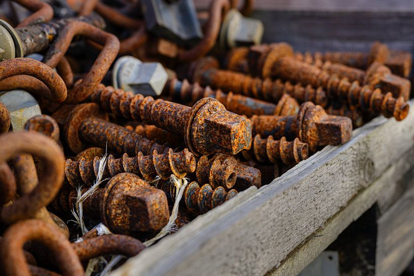 large rusty screws in a wooden box, selected focus, narrow depth of field by Maren Winter
