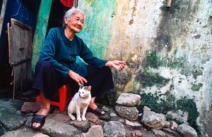 Sitzende Frau mit ihrer weißen Katze in Hoi An - analog