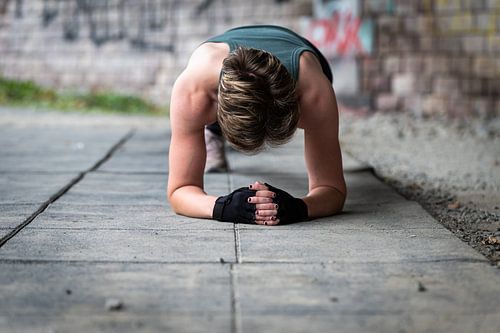 Active 36 year old white woman planking under a bridge outdoors,