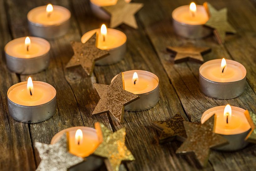Advent and Christmas candle flames with golden star decoration by Alex Winter