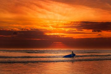 Bali Kuta surfer vrouw in de zee met een krasse rode hemel van Fotos by Jan Wehnert