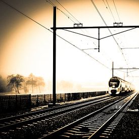 Gekleurde zwart-wit foto van Hollandse trein in mist bij spoorwegovergang sur Hans Post