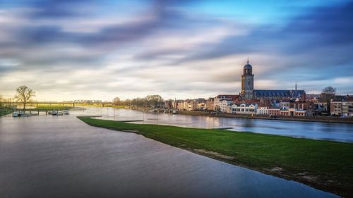 Aangezicht van Deventer genomen met langesluitertijd met mooie wolken en de IJssle op de voorgrond