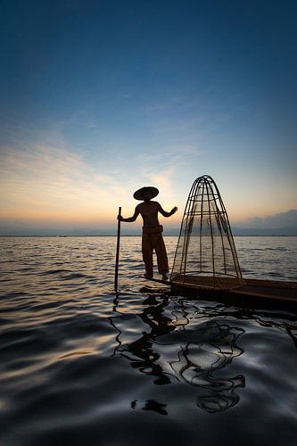 FISHERMAN AT SUNRISE vist ON TRADITIONAL WAY TO INLE LAKE IN MYANMAR. With a basket the fish is caug