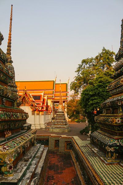 Third sidewalk view to ornate roof, flanked from parts of Chedis at Wat Pho. by kall3bu