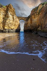 Sonnenuntergang am Praia da Caldeira. Klippen eine brücke über dem Meer einer Bucht bei Lagos, Portuga