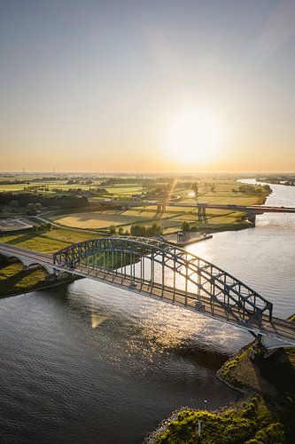 Brug in een kleurrijke lentezonsondergang boven de rivier de IJssel