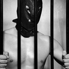 Man achter gevangenis tralies in onderdanige fetisj stijl van Photostudioholland