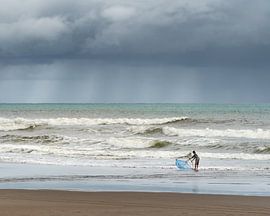 Een visser met een vissersnet op het strand bij Gunung Kidul van Anges van der Logt