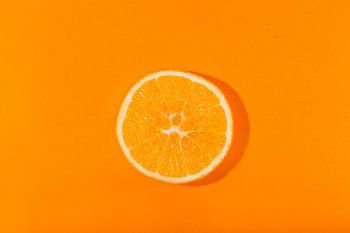 Schijfje sinaasappel tegen een oranje achtergond