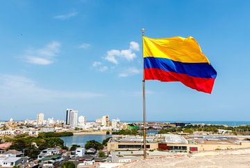 Colombian flag in the wind on the Castillo San Felipe de Barajas fortress with the city of Cartagena by WorldWidePhotoWeb