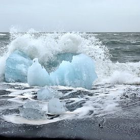 Blauwe ijsschots op vulkaan strand Jokulsarlon met een golf die net op de schots breekt van Jutta Klassen