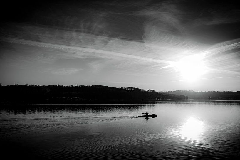 lonely man paddling on Baldeneysee at sunset in black and white by Dieter Walther