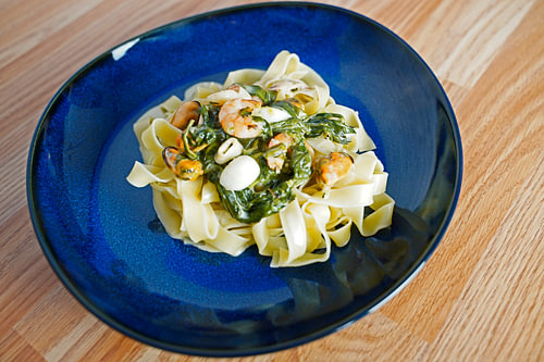 Fettuccini met spinazie en kaas roomsaus en zeevruchten geserveerd op een bord