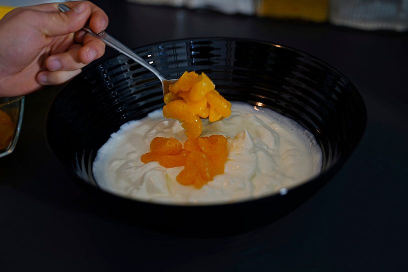 Fold the mandarins with a spoon into the curd-yoghurt mixture in a bowl. by Babetts Bildergalerie
