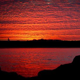 Zonsondergang in Zeeland, de wolkenlucht weerspiegeld in het water van J.A. van den Ende