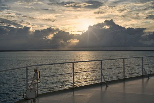 De gloed boven het water vlak voor zonsondergang
