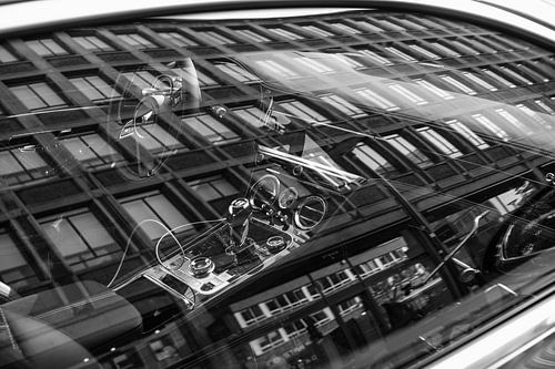 Weerspiegeling van een gebouw in de ruit van een Bentley continental