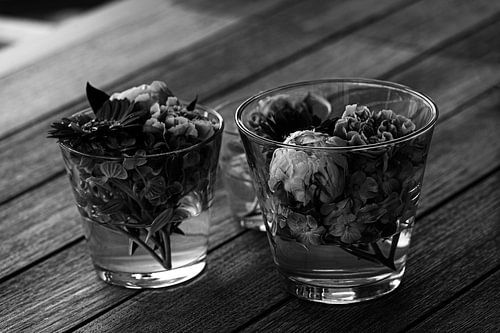 Magnifique mélange de fleurs fraîches disposées dans des vases en verre sur une table en bois en noir et blanc sur Youri Mahieu