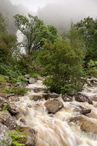 Het water in dit verticale landschap stroomt naar beneden en erboven hangt een bui