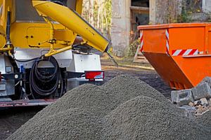 Baufahrzeuge und -geräte beim Aufbringen eines Betonrings auf einen alten Getreidespeicher.