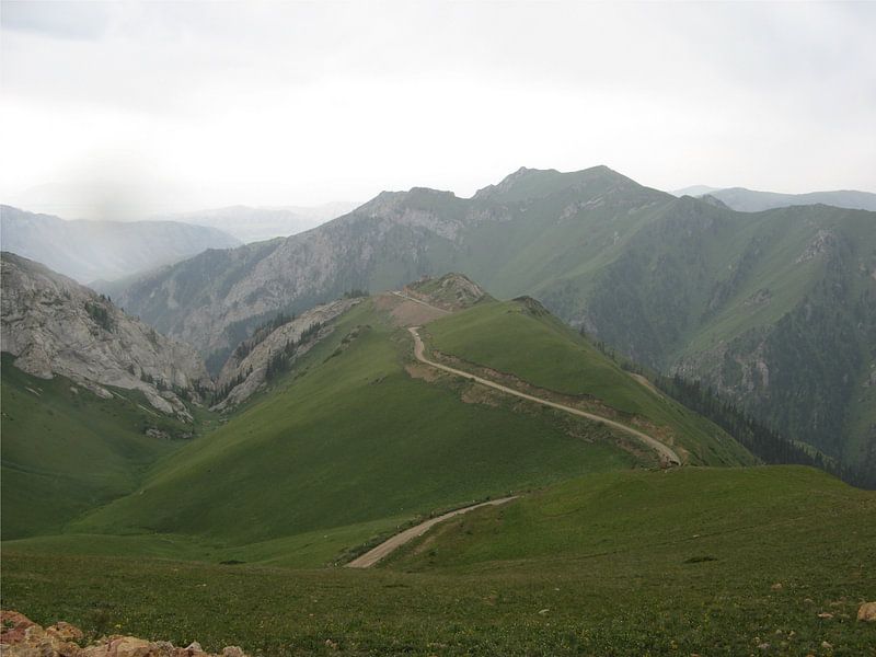 Weg over bergkam in Kirgizië von Toon Loonen