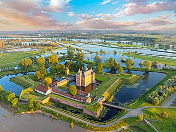 Luchtfoto van een ondergelopen landschap bij  kasteel Loevestein bij Gorinchem in Nederland bij zonsondergang van Eye on You