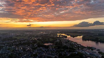 Vurige hemel boven de Maas: Zonsondergang bij Kerkdriel van Franklin Driessen