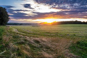Sonnenuntergang über einer hügeligen Landschaft in Dänemark von Evert Jan Luchies