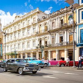 Oldtimer cars drive through the bustling streets of Havana in Cuba