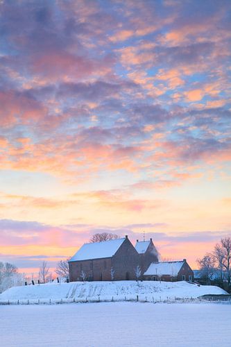 The famous church of Ezinge in a white winter landscape with a beautiful sunrise in Groningen.
