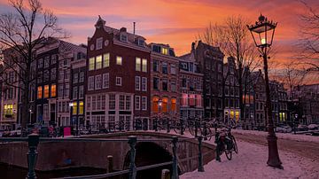 Besneeuwd Amsterdam bij avond in Nederland van Eye on You