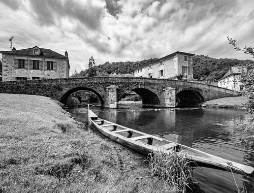 Stenen brug en bootje in dorp in Frankrijk