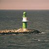 Grüner und weißer Leuchtturm an der Ostsee. Wellen schlagen gegen die Steinkante. Großartiges Signal. von Martin Köbsch