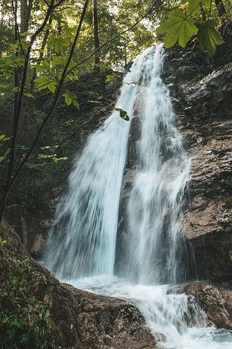 Waterval over de rotsen in het bos