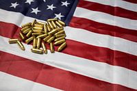 Des balles de fusil à munitions gisant sur le drapeau américain. ÉTATS-UNIS.