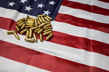 Munitie pistool kogels liggend op de Amerikaanse vlag. USA. van N. Rotteveel