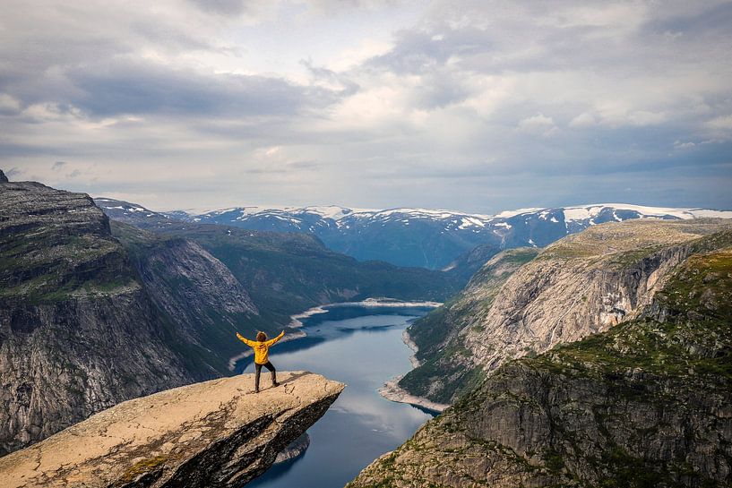 Trolltunga: The yellow man overlooking Ringedalsvannet and snow-capped mountains by Be More Outdoor