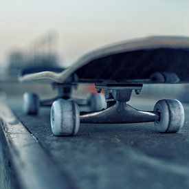 Skateboard on rail in skatepark at evening twilight by Mike Maes