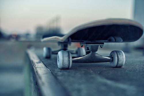 Skateboard on rail in skatepark at evening twilight