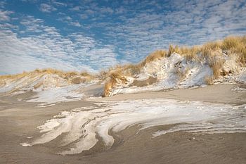 Duinen met poederlaagje sneeuwen prachtige structuren in het zand.