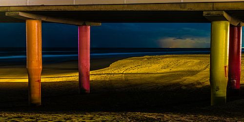 Kleurrijke avond opname van peilers onder de pier van Scheveningen