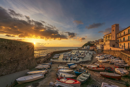 Zonsondergang boven kleine bootjes in de haven van Piombino