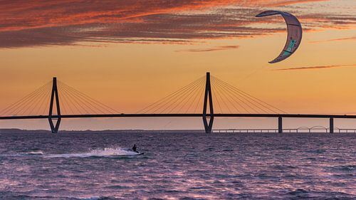 Kitesurfer bij een van de Farø bruggen bij zonsondergang