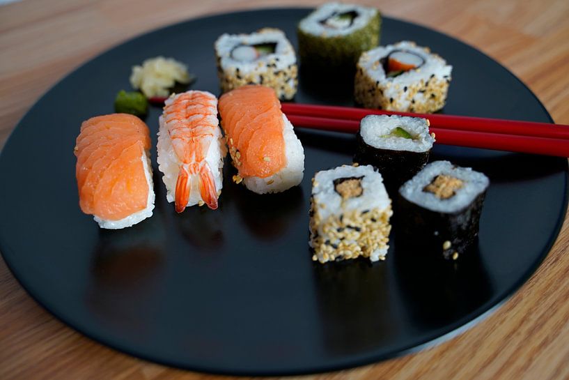 Sushi disposés sur une assiette avec des baguettes. par Babetts Bildergalerie