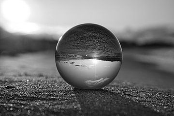 View through the glass ball on the beach. Sea and sky in the background. by Martin Köbsch